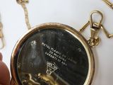 a person holding a gold pocket watch with a chain around it