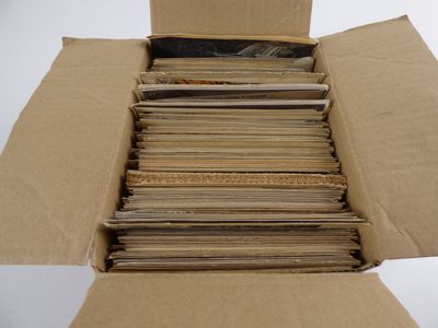 une boîte en carton remplie de vieux disques posée sur une surface blanche