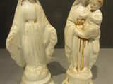 two figurines of the virgin and child are sitting on a table