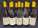 six bouteilles de vin sont alignées sur une table