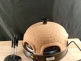 a pizza oven sitting on top of a wooden table