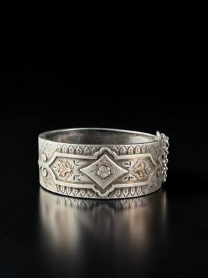 gros plan d'une bague en argent sur une surface noire