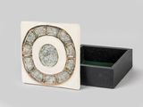 une image représentant une boîte blanche et noire sur laquelle figure une horloge