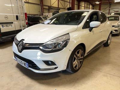 une voiture blanche garée dans un garage, avec d'autres voitures en arrière-plan