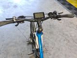 a blue bicycle with a gps device on the handlebars