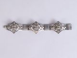 a close up of a silver bracelet on a white surface