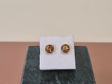 a pair of earrings sitting on top of a marble block