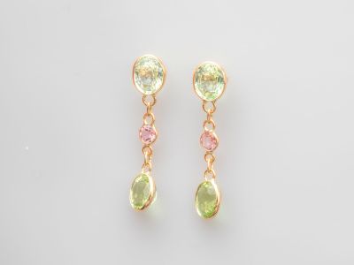 une paire de boucles d'oreilles en tourmaline verte et rose sur fond blanc