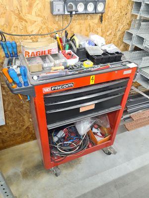 un établi rouge avec des outils dessus, dans un garage