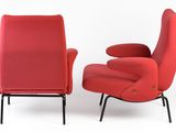 pair of red lounge chairs with black legs and a red upholstered chair