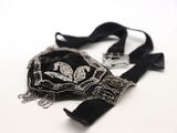 un sac à main noir et argenté posé sur une table blanche