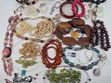 many different types of bracelets and necklaces laid out on a table