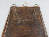 a close up of a brown leather purse on a white surface