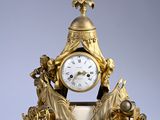 a gold clock sitting on top of a marble table
