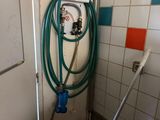 a hose attached to a wall in a bathroom