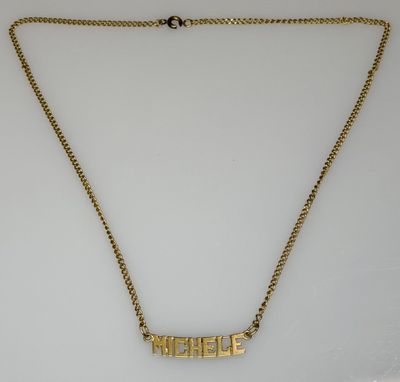 a gold plated necklace with the word ' person ' engraved on it