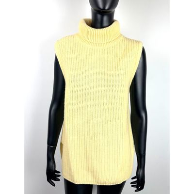 un mannequin portant un pull à col roulé jaune