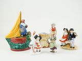 five figurines of different people on a white surface