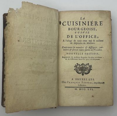 un livre ouvert sur lequel figurent un blason et une couronne