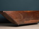 an old wooden bowl sitting on top of a wooden table