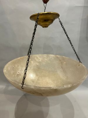 a large bowl hanging from a chain on the wall