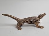brass figurine of a lizard on a white background