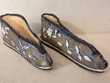 une paire de chaussons bleus et blancs ornés de fleurs