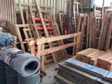 a pile of wooden pallets in a warehouse with other pallets in the background