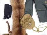 a coat, hat, fur and other items laid out on a table