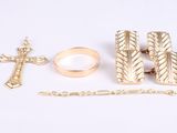 deux bagues, une croix, une chaîne et une bague sur un fond blanc
