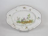a white plate with a bird and flowers on it
