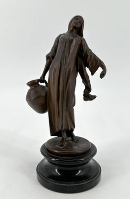 Porteuse d’eau. Statuette en métal à patine brune vers 1900.