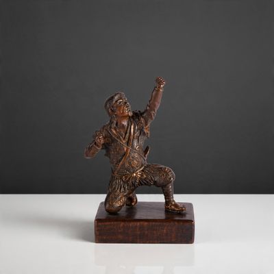 bronze figurine of a man holding a baseball bat on a wooden base