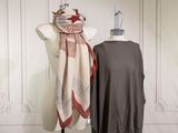 a dress and a scarf on a mannequin in front of a white wall