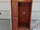 a brown cabinet sitting on a pallet in front of a garage door