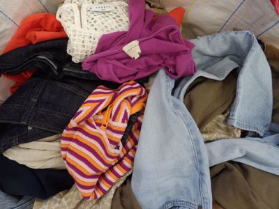 a pile of clothes sitting on top of a bed