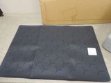 a black mat on the floor next to a cardboard box