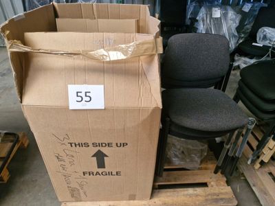 une boîte en carton posée sur une palette, à côté d'une chaise