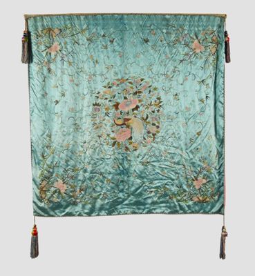 a green and pink floral tapestry hanging on a wall