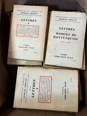 Plusieurs livres sont empilés les uns sur les autres dans une boîte.