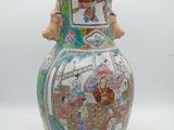 a vase that has a picture of people on it