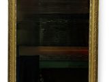 an image of a gold framed mirror hanging on a wall