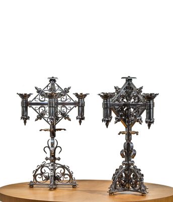 deux bougeoirs en métal posés sur une table en bois, sur fond blanc