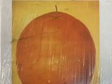 an orange is wrapped in plastic and sitting on a table