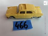 une petite voiture jaune posée à côté d'une feuille de papier bleue