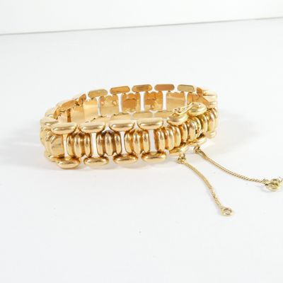 bracelet en or avec une chaîne sur fond blanc