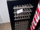 a black refrigerator with a sign on it next to a coke machine