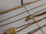 a lot of gold necklaces and bracelets on a table