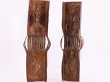 pair of wooden sculptures of a man and a woman with a comb