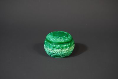 a green glass box sitting on top of a black surface